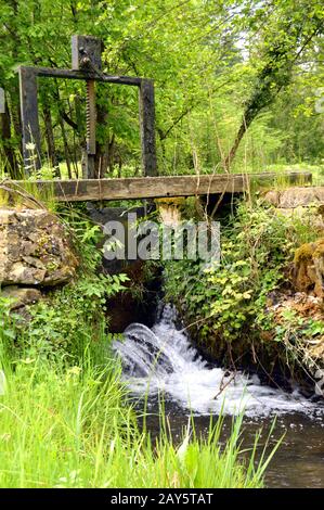 Petit verrou sur un petit ruisseau noir de couleur. Banque D'Images