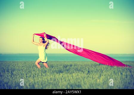 Jeune femme heureuse en champ de blé avec le tissu. Vie d'été Banque D'Images