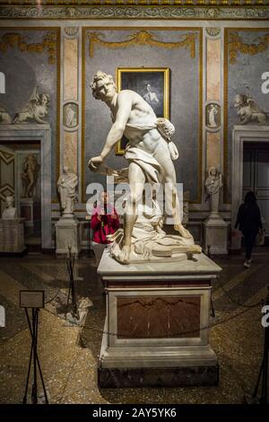 Une femme touristique envisage de prendre une photo d'une célèbre sculpture de David créée par Gian Lorenzo Bernini, Galerie Borghese, Rome, Italie. Banque D'Images