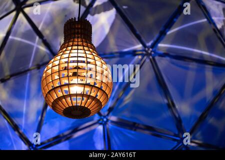 Lampe en bois avec lumière chaude et sphère terrestre bleue sur l'arrière-plan Banque D'Images