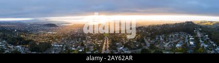 Un beau coucher de soleil illumine les villes d'Oakland, Berkeley, El Cerrito et Richmond dans la région de la baie de San Francisco en Californie. Banque D'Images