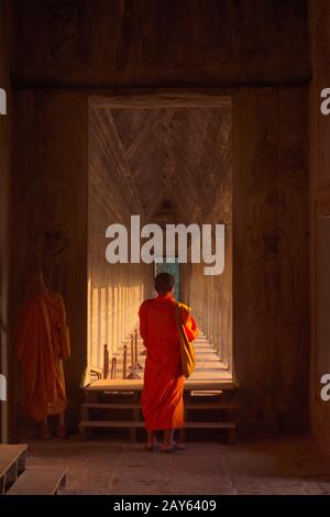 Moine bouddhiste à Angkor Wat, portant des robes de couleur safran traditionnelles, debout sur un si les galeries intérieures. Banque D'Images