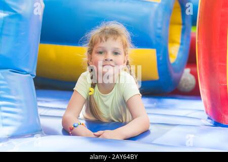 Échevelé fille de cinq ans est de jouer sur un grand trampoline gonflable Banque D'Images