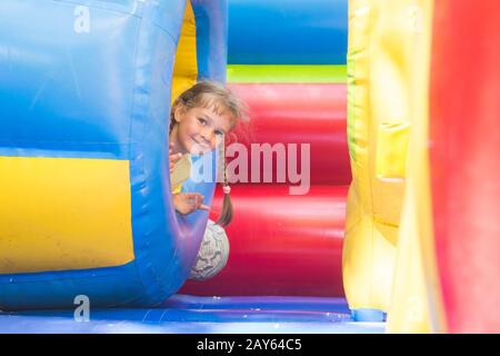 Happy little girl est sorti de l'élément gonflable soft canon tout en jouant sur le trampoline Banque D'Images