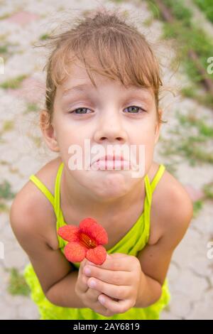 Funny Girl avec une fleur dans sa main d'un mendiant accroupi face à la recherche sur le châssis Banque D'Images