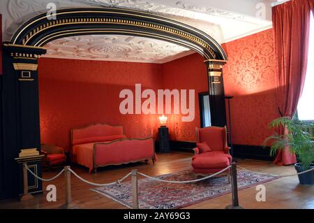 Chambre rouge avec un arc et moulures au plafond. Banque D'Images