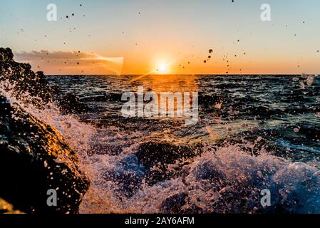 Beau coucher de soleil avec vagues écrasant, Grèce Banque D'Images