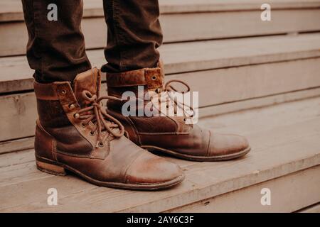 Image des chaussures marron mans sur des marches en bois. Homme en pantalon et chaussures escarpées au seuil. Vue horizontale Banque D'Images