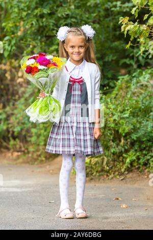 Portrait d'une durée de sept ans, première année de fille avec un bouquet de fleurs Banque D'Images