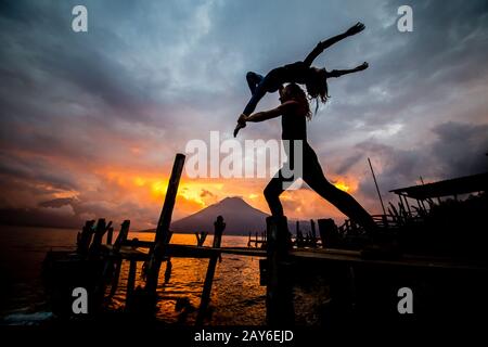 Acroyoga au coucher du soleil sur le lac Banque D'Images