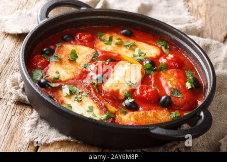 Fromage Halloumi traditionnel avec tomates, poivrons, olives dans une sauce épicée dans une poêle sur la table. Horizontale Banque D'Images