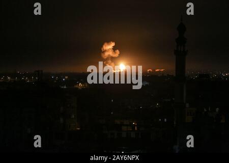 Une boule de feu et de fumée s'élève au-dessus des bâtiments lors des frappes aériennes israéliennes visant des positions de Qassam, le Hamas, dans la bande de Gaza, le 05 février 2020. Banque D'Images