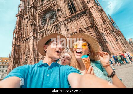 Groupe multi-ethnique d'amis Avec plaisir et dégustation de glaces à l'arrière-plan de la cathédrale notre Dame de Strasbourg Banque D'Images