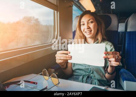 Jeune femme asiatique voyageant en train et montrant son billet au chef d'orchestre Banque D'Images