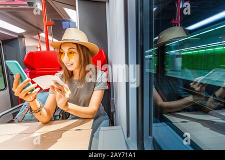 Femme asiatique achetant des billets par son smartphone à long train éloigné Banque D'Images