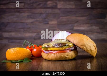 Hamburger végétarien avec fromage, orange, feuilles de basilic, champignons shiitake et oignon violet sur table en bois et fond rustique Banque D'Images