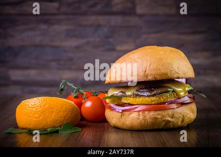 Hamburger végétarien avec fromage, orange, feuilles de basilic, champignons shiitake et oignon violet sur table en bois et fond rustique Banque D'Images