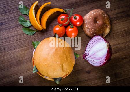 Hamburger végétarien avec fromage, orange, feuilles de basilic, champignons shiitake et oignon violet sur table en bois et fond rustique Banque D'Images