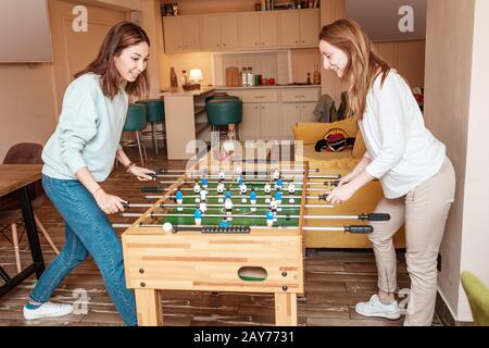 Amis filles prendre une pause et jouer au baby-foot et s'amuser Banque D'Images