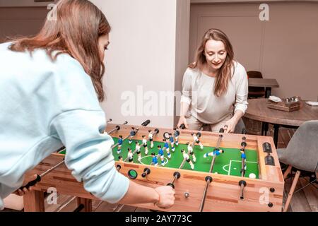 Amis filles prendre une pause et jouer au baby-foot et s'amuser Banque D'Images