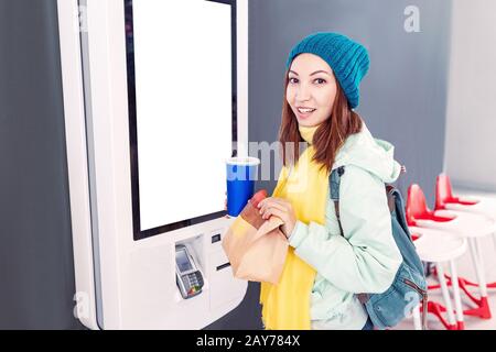 Une femme commande des aliments dans le terminal à écran tactile avec un menu électronique dans le restaurant Fast-food Banque D'Images