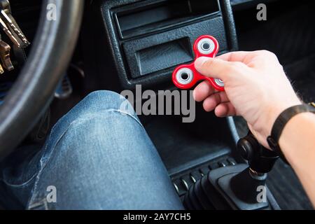 Gros plan sur la main d'un homme jouant avec un disque alors dans un bourrage de circulation sur l'arrière-plan de l'intérieur de la voiture Banque D'Images