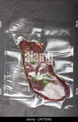 Steak cru dans un sac sous vide Banque D'Images