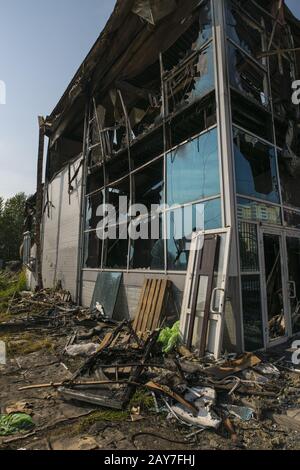 Construction brûlé avec des fenêtres cassées en été Banque D'Images