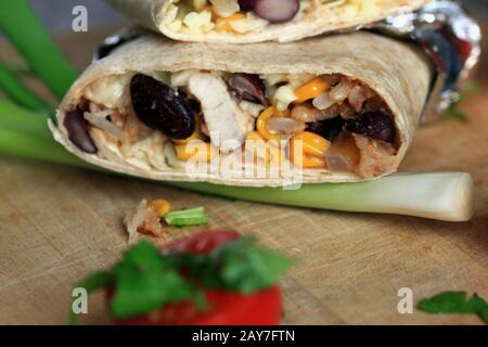 Burrito maison. Tortilla avec légumes et fromage. Légumes frais avec sauce à l'ail. Alimentation saine. Délicieux Déjeuner. Banque D'Images