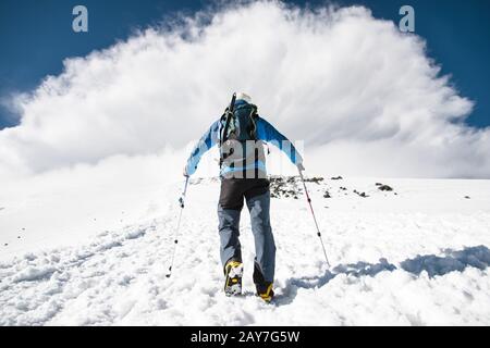 Mountaineer monte en montée pour rencontrer une tempête de montagne venant de la montagne Banque D'Images