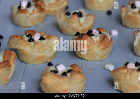 Biscuits à la pâte feuilletée avec pudding et chocolat. Biscuits faits maison. Muffins avec pouding. Bonbons sains. Banque D'Images