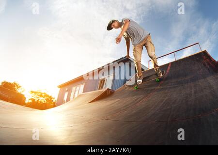 Skater pour adolescents accroché sur une rampe sur un skateboard dans un parc de skate Banque D'Images