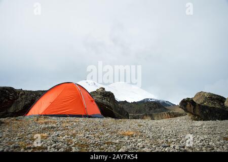 Une tente orange de haute altitude est installée dans les montagnes sur le fond de la crête caucasienne Banque D'Images