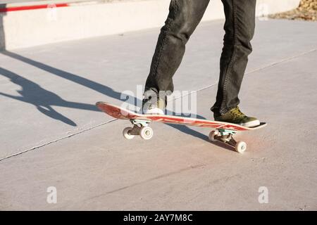 Un jeune gars sur un skateboard dans un manuel sur un skatepark sur l'arrière-plan de la maison Banque D'Images