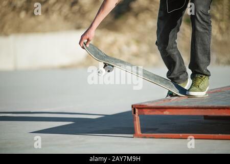 Un jeune gars sur un skateboard dans un manuel sur un skatepark sur l'arrière-plan de la maison Banque D'Images