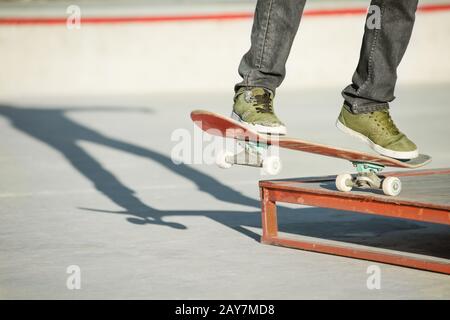 Un jeune gars sur un skateboard dans un manuel sur un skatepark sur l'arrière-plan de la maison Banque D'Images