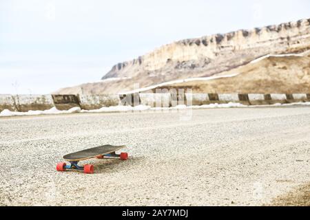 Une longboard solitaire sur une serpentine de montagne, une route d'asphalte sur fond de montagnes Banque D'Images