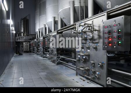 Réservoirs en acier inoxydable pour le stockage de la bière dans une pièce avec un panneau de commande, des tuyaux, des écrans technologiques Banque D'Images