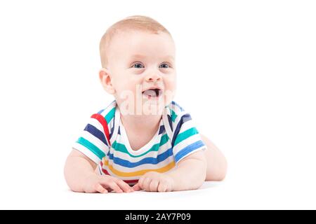 Mignon petit garçon étonné en chemise colorée se trouve sur le ventre Banque D'Images