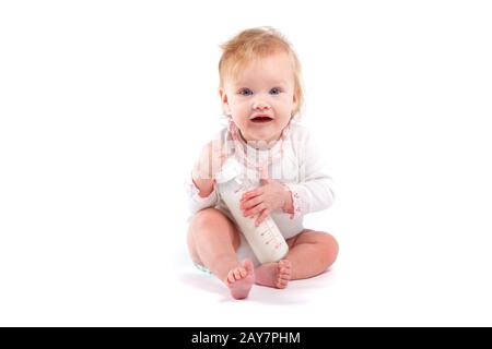 Cute little girl en chemise blanche avec du lait Banque D'Images