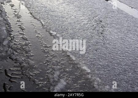 une humidité en neige sur la couche régulière de la route plus mince. Banque D'Images