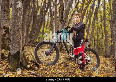 Portrait d'un jeune pilote en pleine protection d'un masque de casque intégral et de gants sur un vélo Banque D'Images