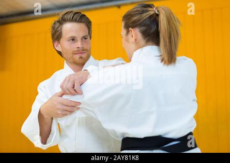 Jeune femme et l'homme chasse en judo sport hall Banque D'Images