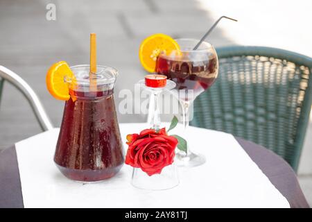 Pichet et verre avec délicieux vin sangria rafraîchissant sur table dans le café, à l'extérieur Banque D'Images