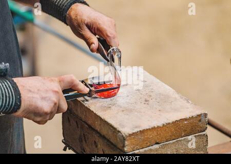 Artiste Homme Mains gros plan travailler sur une forme de verre chaud en atelier Banque D'Images