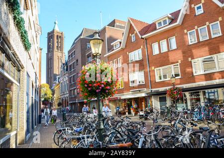 Venlo, Limbourg, Pays-Bas - 13 octobre 2018 : rue commerçante dans le centre historique de la ville néerlandaise. Vélos stationnés au premier plan. Les gens marchant dans la rue. Tour en arrière-plan. Banque D'Images