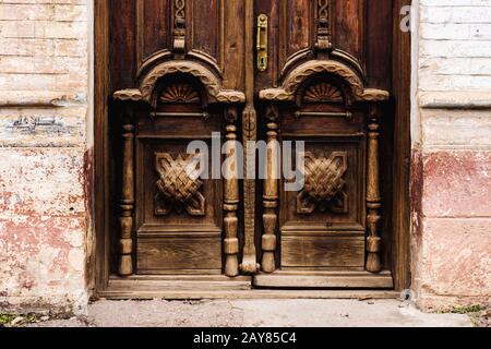 Arrière-plan vintage. Éléments d'une ancienne porte en bois sculpté décorée d'éléments en bois sculpté volumineux imitant le tissage Banque D'Images