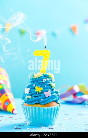 Septième cupcake d'anniversaire avec coup de bougie.maquette de carte. Banque D'Images