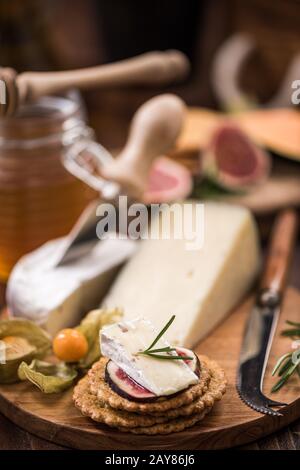 Crackers au fromage avec camembert, miel, figue et herbe Banque D'Images