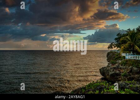ciel spectaculaire au coucher du soleil sur la mer et la terre rocheuse Banque D'Images